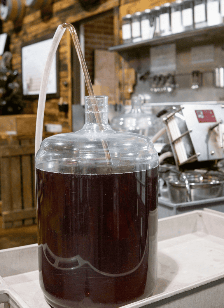 Racking red wine off its sediment with a siphon at Corkit Winemaking in North Vancouver