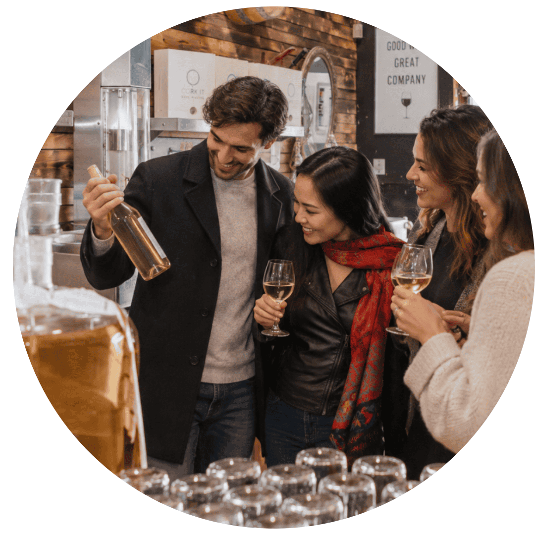 A wedding party bottling wine together at Cork It