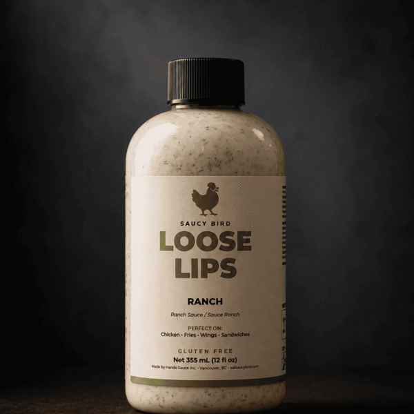 Bottle of Saucy Bird Loose Lips Ranch Sauce, a creamy speckled ranch, 355 mL, on a dark background