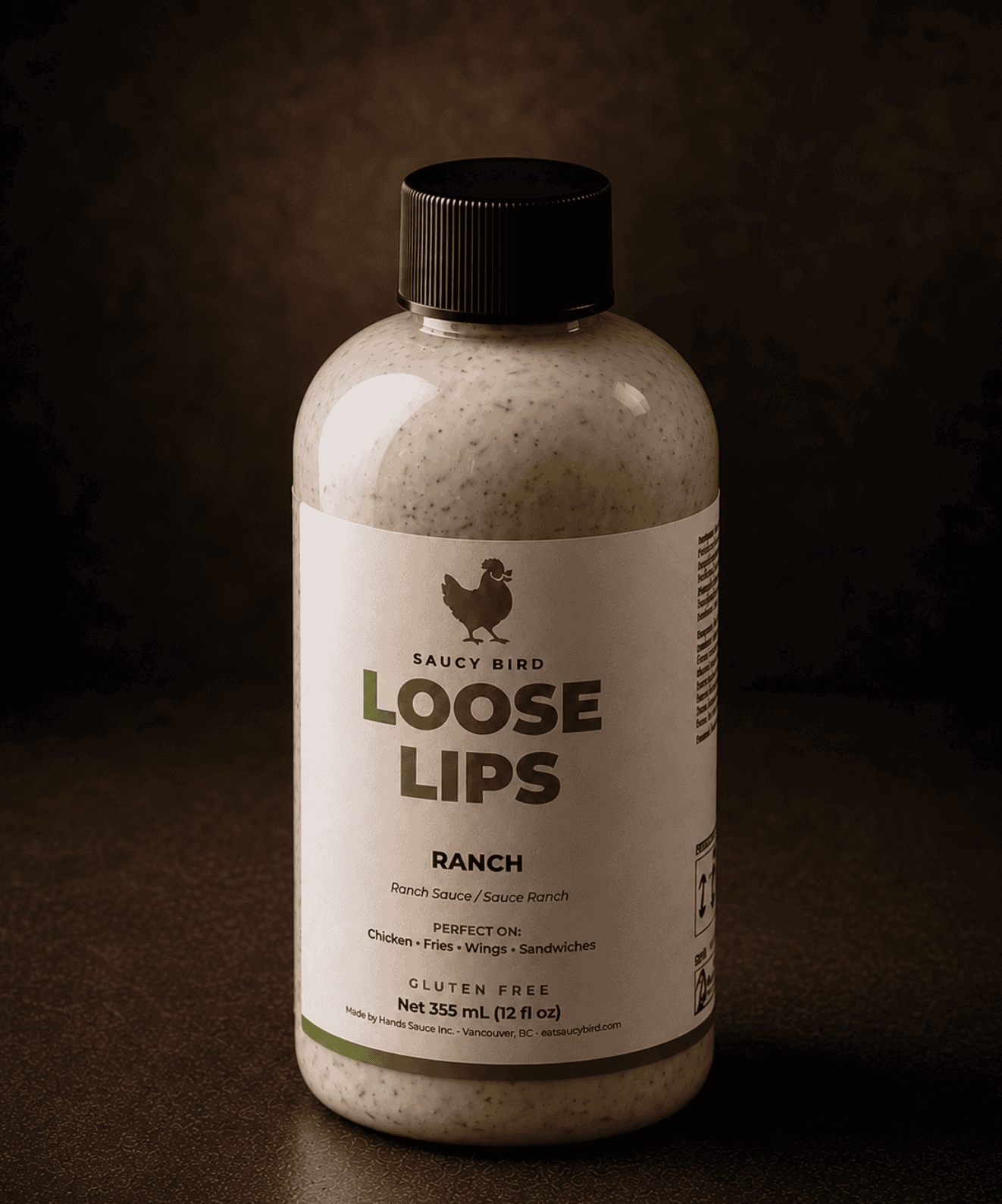 Bottle of Saucy Bird Loose Lips Ranch Sauce on a warm dark background