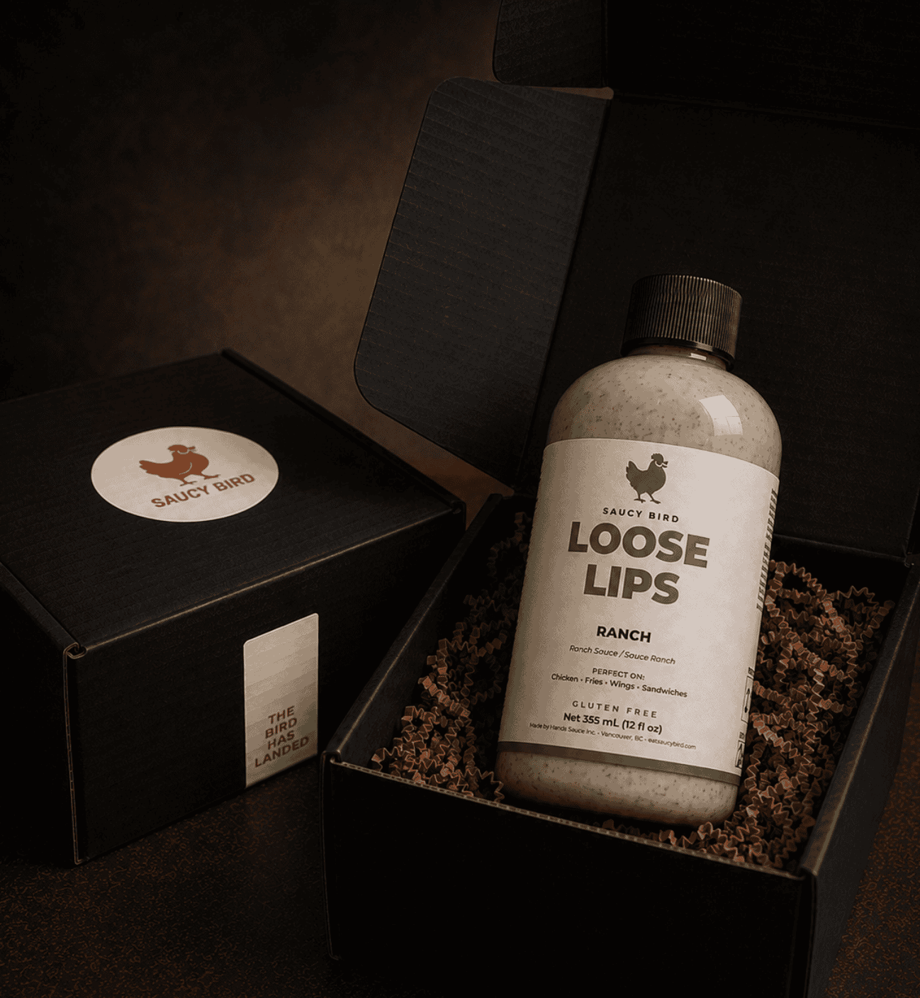 Bottle of Saucy Bird Loose Lips Ranch Sauce in an open black Saucy Bird gift box