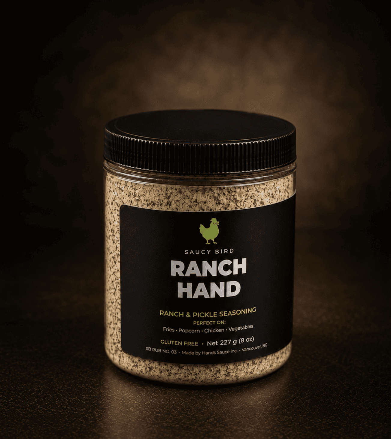 Jar of Saucy Bird Ranch Hand ranch and pickle seasoning, 227 g, glowing against a dark background