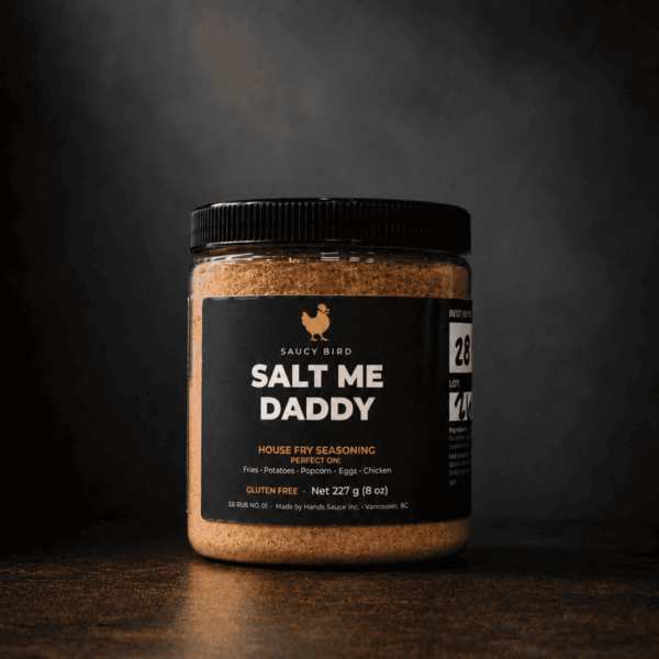 Jar of Saucy Bird Salt Me Daddy house fry seasoning, 227 g, on a dark background
