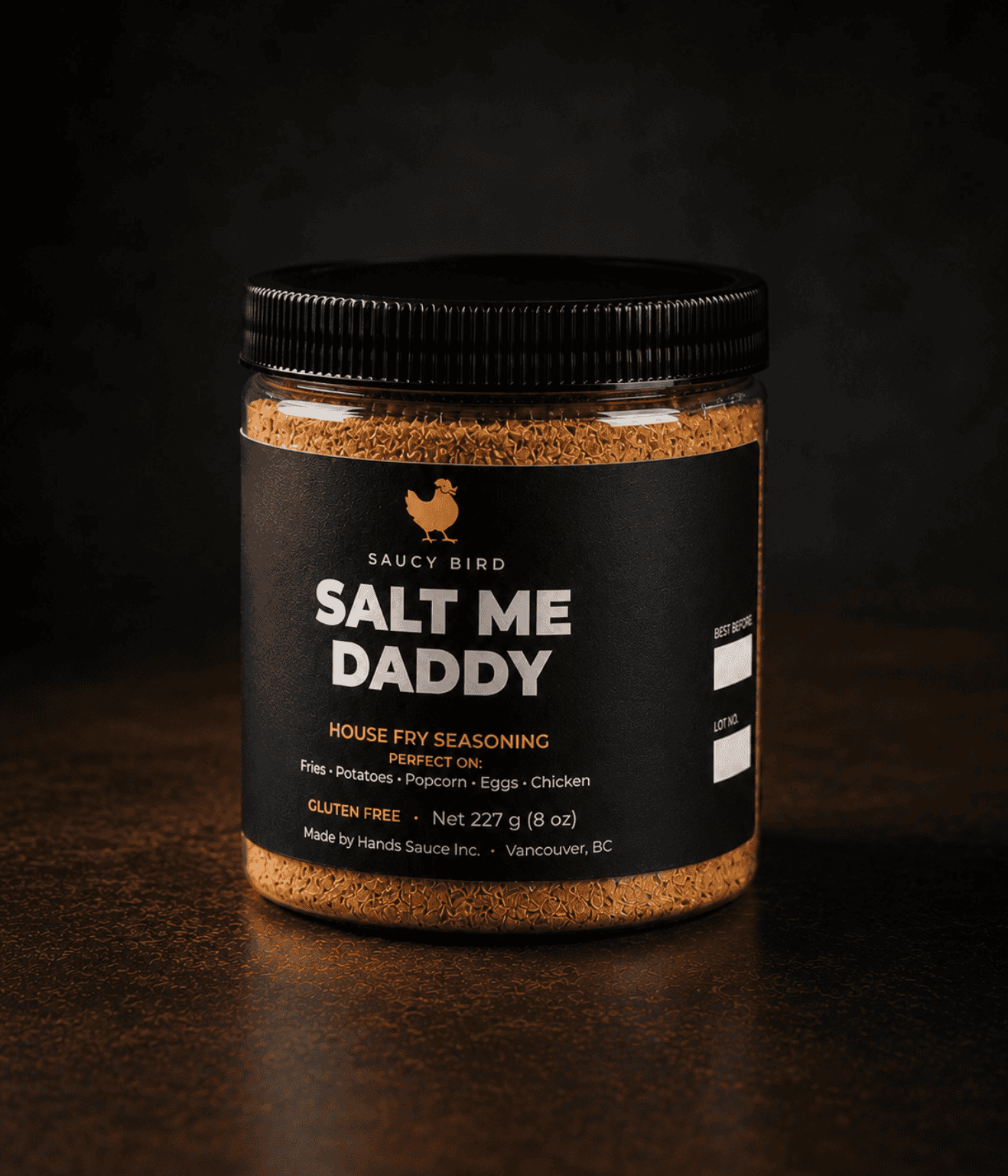 Jar of Saucy Bird Salt Me Daddy house fry seasoning shown front-on against a dark background