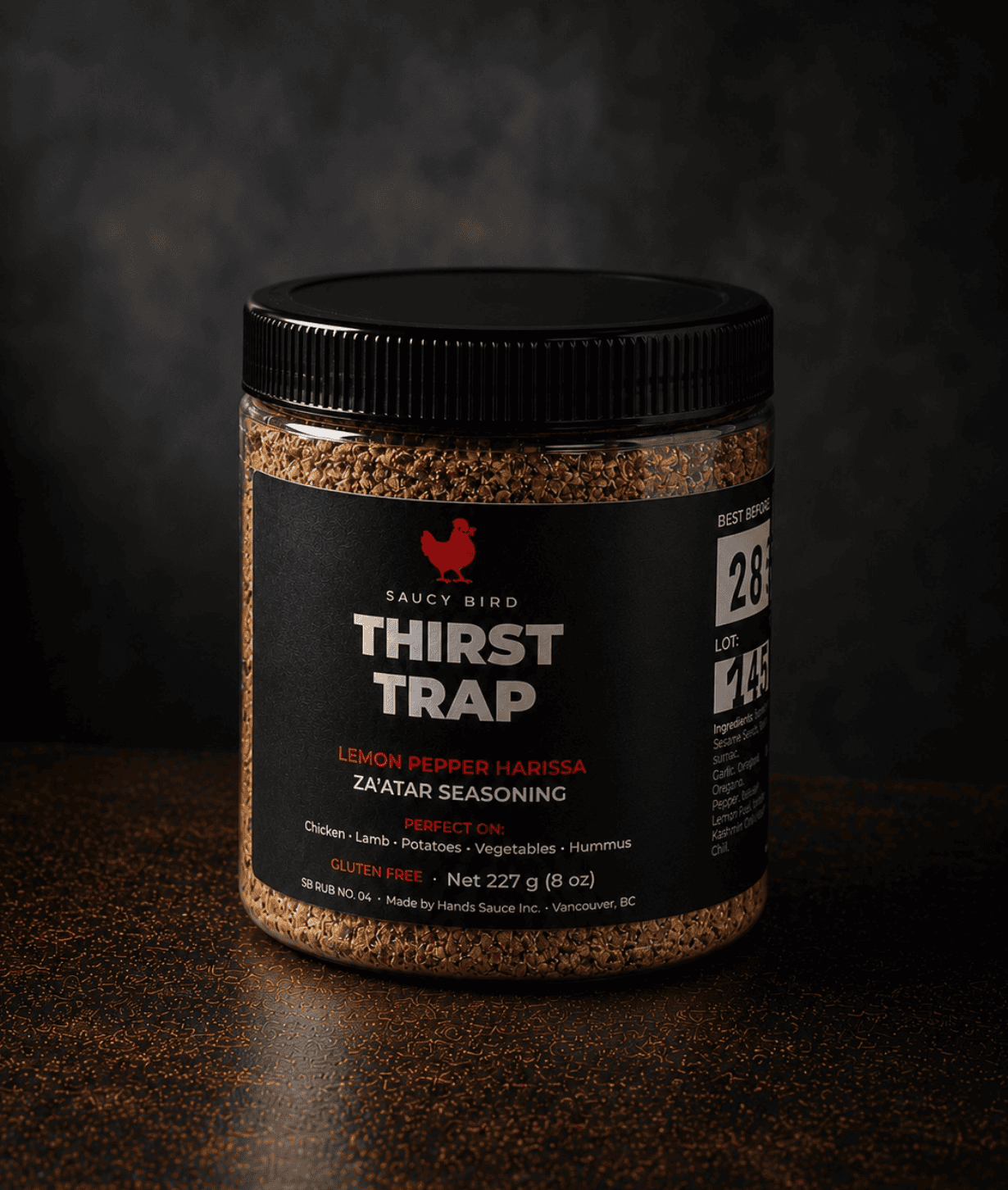 Jar of Saucy Bird Thirst Trap lemon pepper harissa za'atar seasoning, 227 g, on a dark background