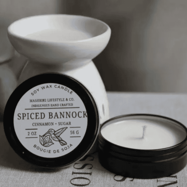 Mashkiki Spiced Bannock 2 oz soy wax candle tin in Cinnamon + Sugar, lid off beside a wax warmer