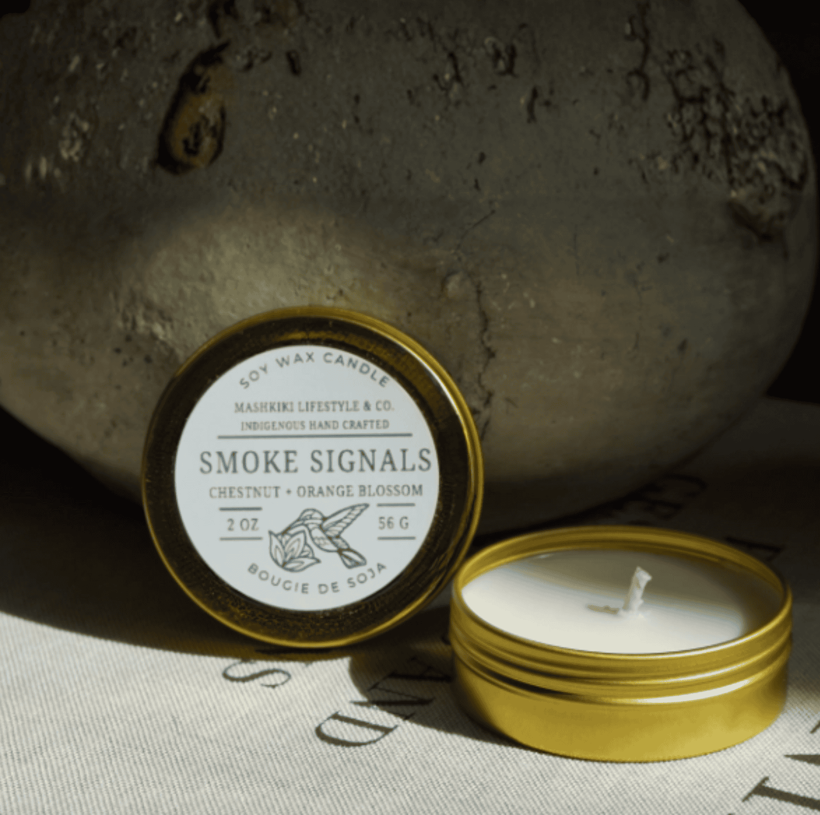 Mashkiki Smoke Signals 2 oz soy candle in a gold tin, Chestnut + Orange Blossom, lid off