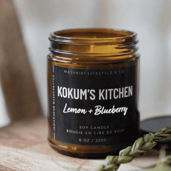 Mashkiki Kokum's Kitchen 8 oz amber glass soy candle, Lemon + Blueberry, beside a sweetgrass braid
