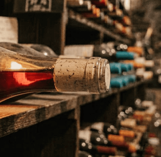 Wine resting against the cork in a bottle stored on its side in a cellar rack
