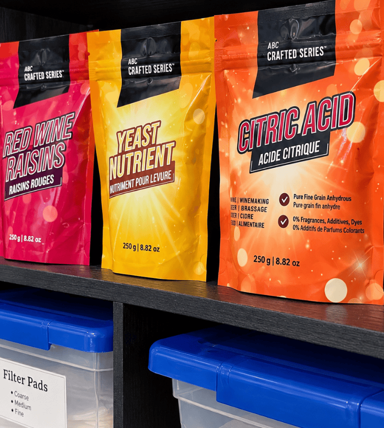 Shelf of home winemaking supplies including yeast nutrient, citric acid, red wine raisins and filter pads